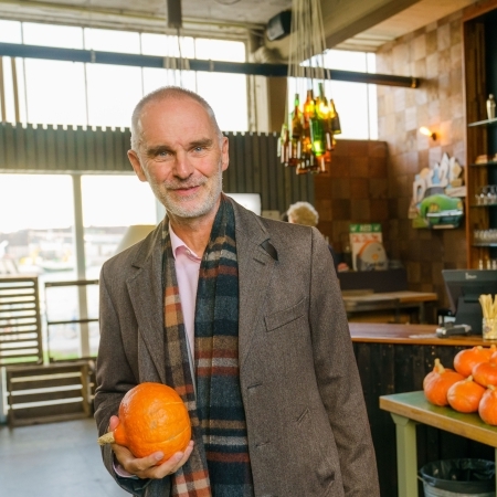 Hanno Pijl met een pompoen in de hand in een gebouw